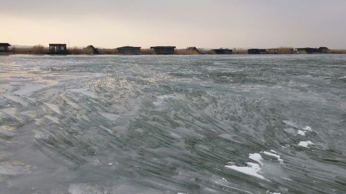 Scenic view of frozen beach against clear sky