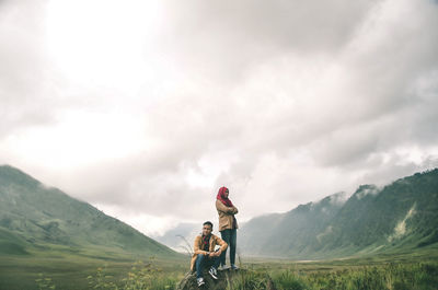 People on mountain against sky