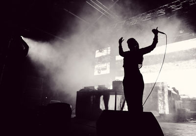 Silhouette woman performing on stage at music concert