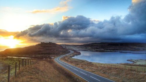 Road by landscape against sky