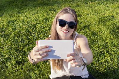 Young woman using mobile phone in field