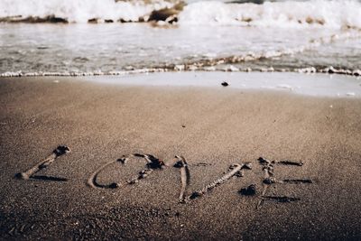 Text written on sand at beach