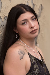 Close-up portrait of young woman against wall