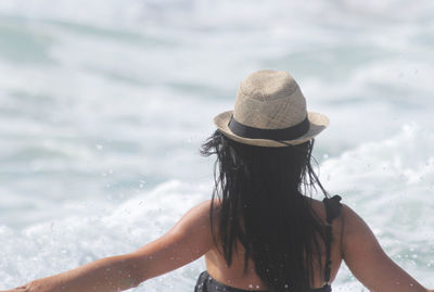 Rear view of woman wearing hat against sea