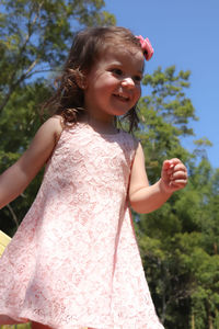 Cute smiling girl standing against on tree