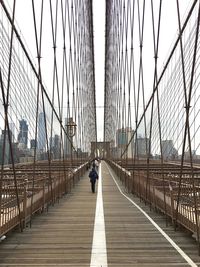 Man walking on footbridge in city