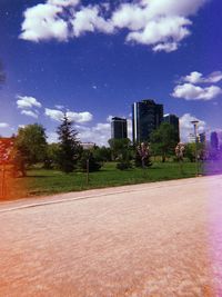 Street by buildings in city against sky