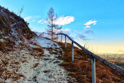 Snow covered railing against sky