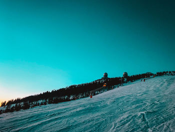 Scenic view of snow covered land against clear blue sky