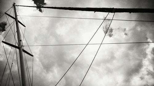 Low angle view of cables against cloudy sky