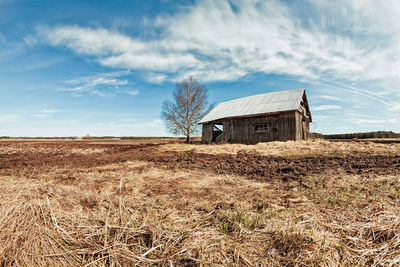 Abandoned barn on field against sky