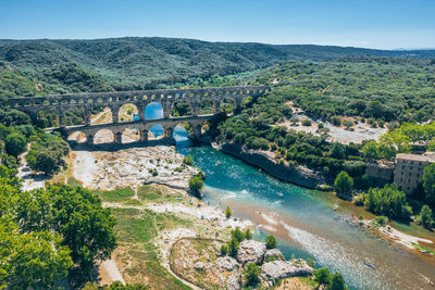 High angle view of river amidst green landscape against sky