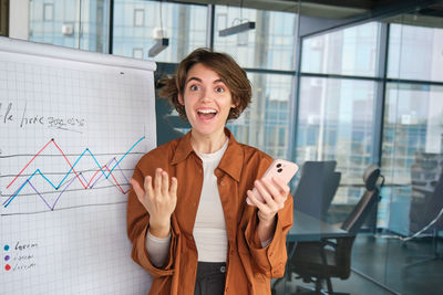 Portrait of young businesswoman standing in city