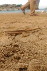 Low section of person on sand at beach