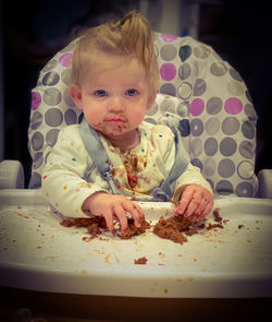 Portrait of cute baby girl sitting on table