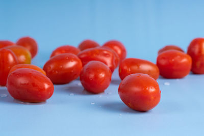 Close-up of tomatoes on table against blue background