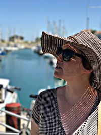 Close-up of woman in sunglasses against boat sailing in sea