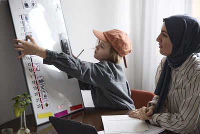 Mother teaching son at home