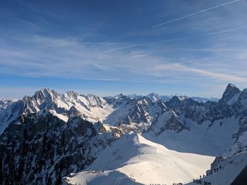 Scenic view of snowcapped mountains against blue sky