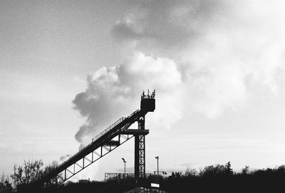 Low angle view of silhouette crane against sky