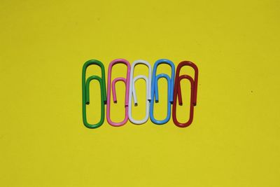 Close-up of multi colored pencils on yellow wall