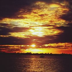 Scenic view of sea against dramatic sky during sunset