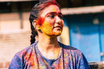 Young woman with powder paint on face during holi