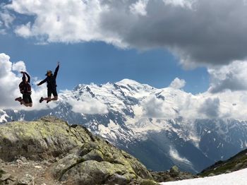 People jumping over mountain during winter