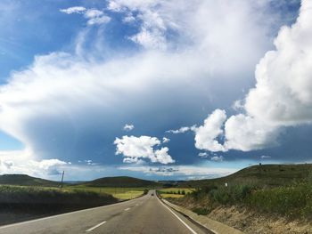 Road passing through landscape against sky