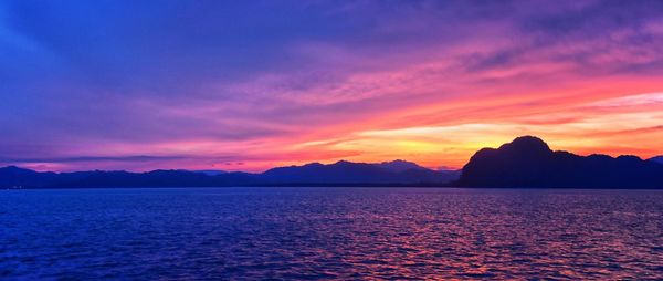 Scenic view of sea against dramatic sky during sunset