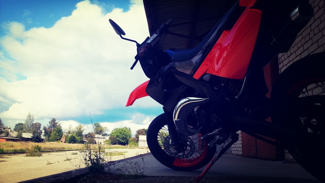 transportation, mode of transport, land vehicle, bicycle, stationary, parked, parking, car, sky, travel, motorcycle, road, street, day, outdoors, wheel, cloud - sky, red, no people, parking lot