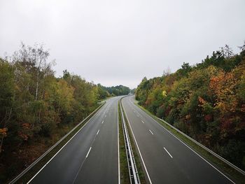 Road amidst trees against sky