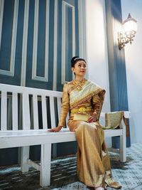 Beautiful woman sitting on bench at home