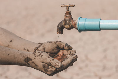 Close-up of hand holding rusty pipe