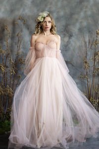 A young blonde in an airy tulle pink dress. spring portrait of a woman.