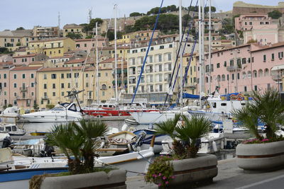 Sailboats moored by buildings in city