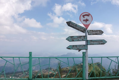 Close-up of road sign against sky