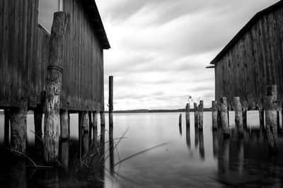 Wooden posts on house by building against sky