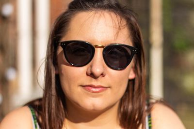 Close-up portrait of woman wearing sunglasses in sunny day