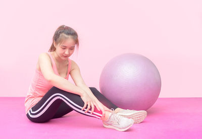 Full length of woman sitting against background