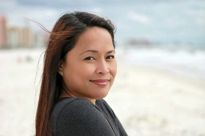 Close-up portrait of smiling beautiful woman at beach