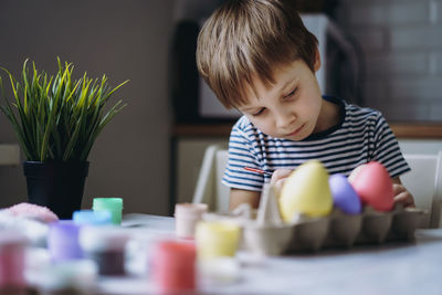 Side view of boy playing with toys at home
