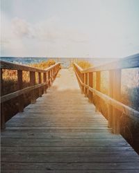 Boardwalk on beach against sky
