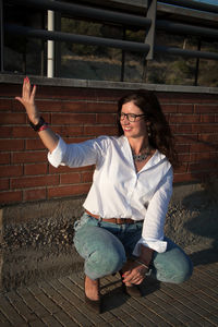 Portrait of young woman standing against wall