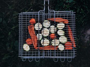 Directly above shot of vegetables in barbecue grill on field