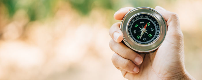 Close-up of hand holding navigational compass