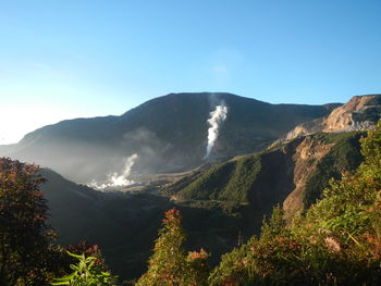 Scenic view of mountains against blue sky