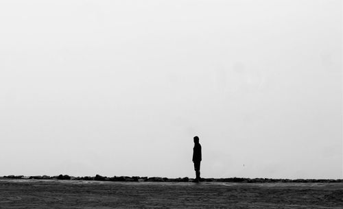 Side view of silhouette man standing on field