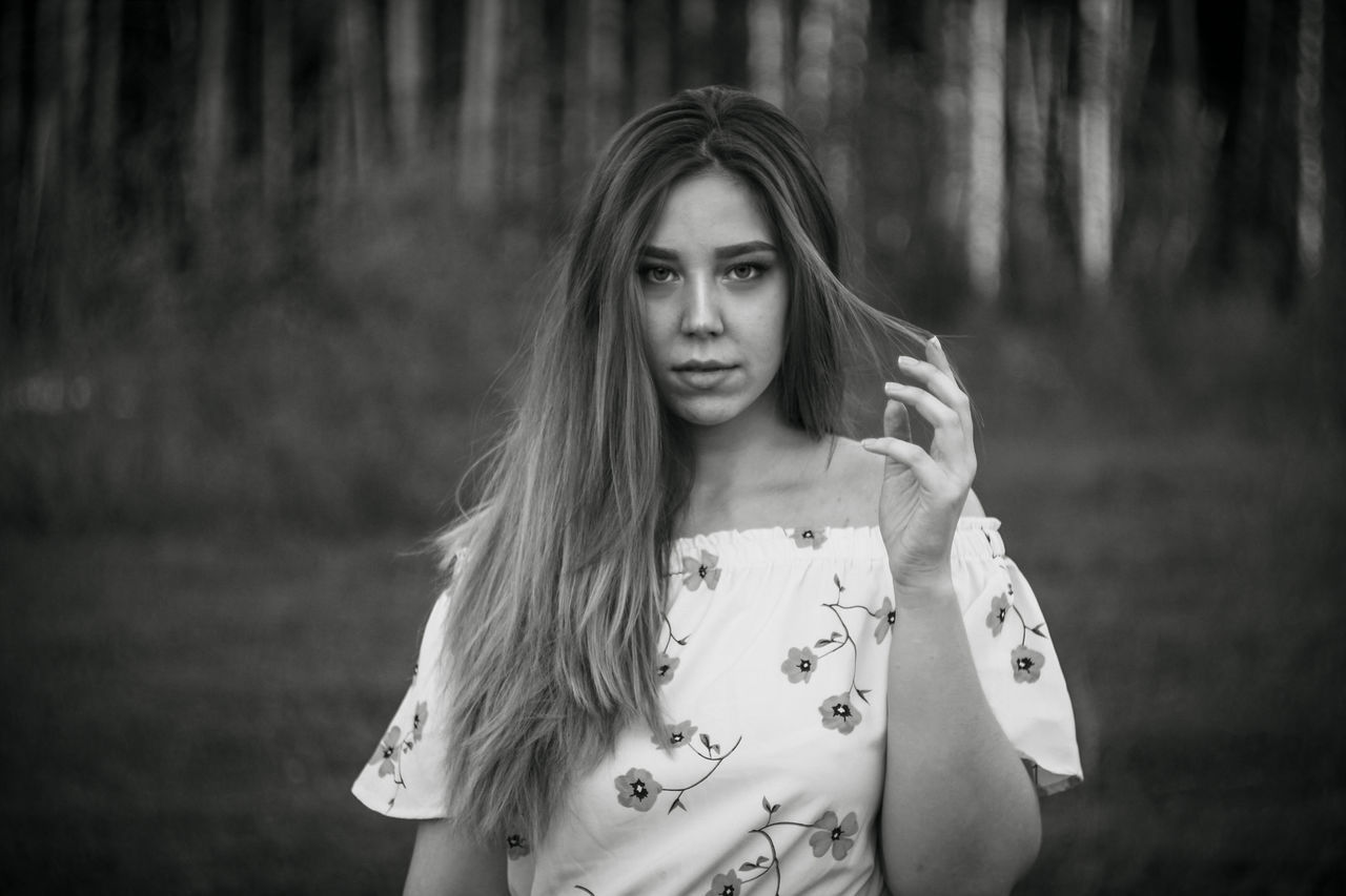 long hair, portrait photography, one person, portrait, women, white, black and white, hairstyle, female, young adult, adult, looking at camera, darkness, monochrome photography, person, nature, land, black, tree, monochrome, front view, child, focus on foreground, forest, standing, photo shoot, plant, emotion, waist up, fashion, lifestyles, outdoors, human face, childhood, teenager, blond hair, casual clothing, clothing