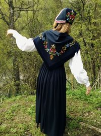 Rear view of woman standing on field